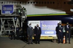 Brazil's Health Minister Eduardo Pazuello, other Brazilian officials and India's ambassador attend a ceremony where 2 million doses of AstraZeneca/Oxford vaccines from India are being transported to Rio de Janeiro at Sao Paulo Airport, Jan. 22, 2021.