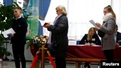 People queue to cast their vote at a polling station during the parliamentary election in Minsk, Belarus, Nov. 17, 2019.