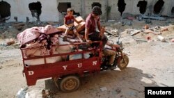 A Palestinian family salvages belongings from the ruins of buildings destroyed by what police said were Israeli airstrikes and shelling in Khuzaa, east of Khan Younis, in the southern Gaza Strip, August 3, 2014. 