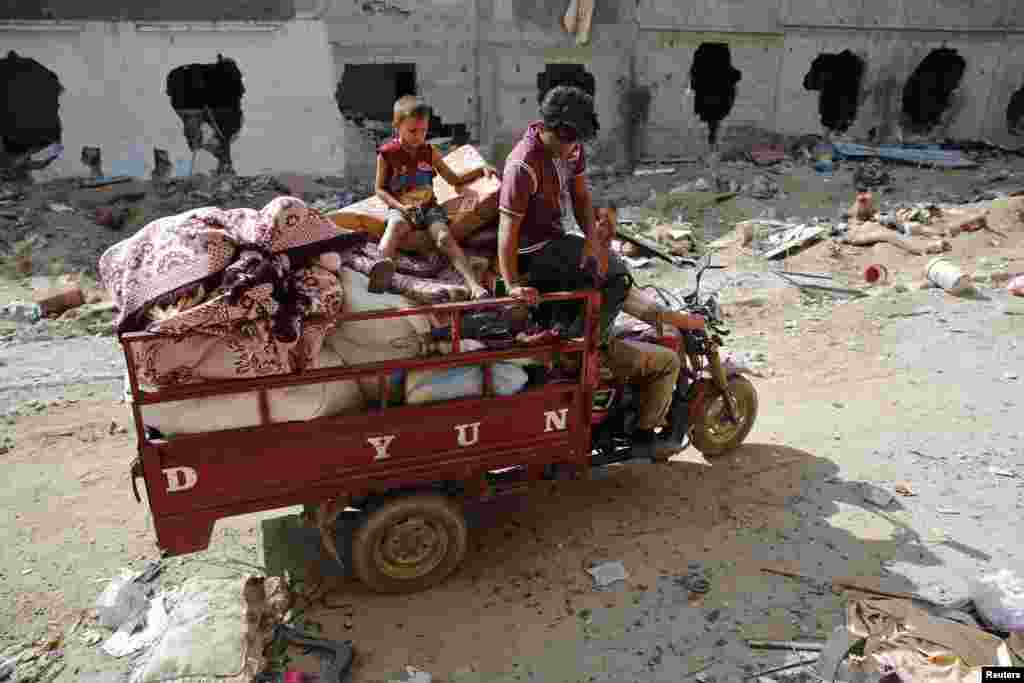 A Palestinian family salvages belongings from the ruins of buildings destroyed by what police said were Israeli airstrikes and shelling in Khuzaa, east of Khan Younis, in the southern Gaza Strip, August 3, 2014. 
