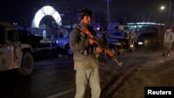 FILE - An Afghan police officer keeps watch at the site of a bomb attack, suspected to be the work of Islamic State's Afghan branch, in Kabul, Afghanistan, Nov. 20, 2018. 