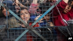 کودکان فلسطینی برای گرفتن غذا در کمپ پناهندگان صف کشیده‌اند.