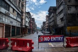 Indian youngsters play cricket in barricaded street during the reimposed lockdown in Gauhati, India, June 29, 2020.
