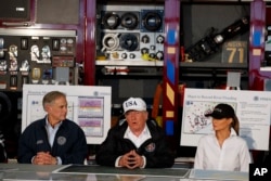 President Donald Trump, flanked by Texas Gov. Greg Abbott and first lady Melania Trump, speaks during a briefing on Harvey relief efforts, Aug. 29, 2017, in Corpus Christi, Texas.