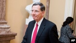 FILE - Sen. John Barrasso, left, walks to a meeting on Capitol Hill, Feb. 11, 2019, in Washington.