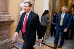 FILE - Sen. John Barrasso, left, walks to a meeting on Capitol Hill, Feb. 11, 2019, in Washington.