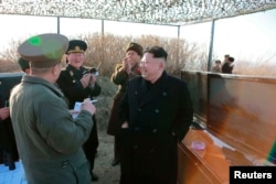North Korean leader Kim Jong Un and officials observe the test firing of a new type of anti-ship cruise missile in this undated photo released by North Korea's Korean Central News Agency in Pyongyang, Feb. 7, 2015.