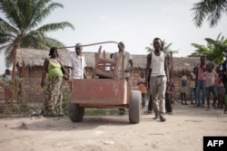FILE - A Central African Republic family moves their belongings as they leave after four years spent in a refugee camp in Betou, northern Congo-Brazzaville, on March 30, 2018, as CAR refugees are taken back to Central Africa Republic.