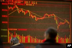 Chinese investors monitor stock prices at a brokerage house in Beijing, Friday, March 23, 2018.