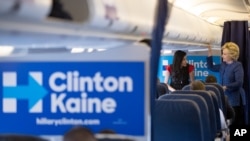 Hillary Clinton speaks with senior aide Huma Abedin (L) aboard her campaign plane at an airport in White Plains, New York, Oct. 28, 2016. The FBI found the potentially incriminating emails on a computer Abedin shared with her estranged husband.