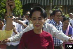FILE - Myanmar opposition leader and head of the National League for Democracy (NLD) Aung San Suu Kyi (C) visits a polling station in Kawhmu township, Yangon, Nov. 8, 2015.