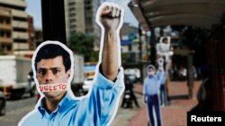 Cardboard figures of jailed opposition leader Leopoldo Lopez with his mouth covered with the word 'Crime' are seen during a gathering in support of him in Caracas, June 4, 2014. 