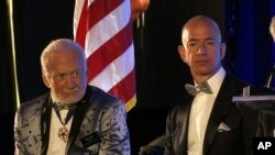 Apollo 11 astronaut Buzz Aldrin, left, and Amazon.com and Blue Origins founder Jeff Bezos attend the commemoration for the upcoming anniversary of the 1969 mission to the moon and a gala for Aldrin's nonprofit space education foundation, ShareSpaceFoundation, at the Kennedy Space Center in Cape Canaveral, Fla., July 15, 2017. 