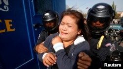 A protester is detained during an attempt to deliver a petition, near the French embassy, in Phnom Penh January 21, 2014. Eleven protesters, including Cambodian activists Yorm Bopha and Tep Vanny, were detained while trying to deliver petitions to foreign embassies in Phnom Penh, calling for help in securing the release of 23 men who were jailed for joining a strike earlier this month over garment factory wages, according to local rights groups.