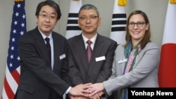 16일 한국국방부 청사에서 열린 '제8차 미한일 안보회의(DTT)'에서 각국 수석대표들이 손을 맞잡고 있다. 왼쪽부터 마에다 사토시 일본 방위성 방위정책국장, 류제승 한국 국방부 국방정책실장, 켈리 맥사멘 미국 국방부 아태안보차관보.