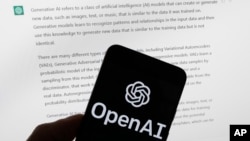 FILE - The OpenAI logo is seen on a mobile phone in front of a computer screen displaying output from ChatGPT, on March 21, 2023, in Boston. (AP Photo/Michael Dwyer, File)