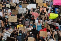 FILE - Demonstrators march on pavement, Sunday, May 31, 2020, in Minneapolis. Protests continued following the death of George Floyd, who died after being restrained by Minneapolis police officers on May 25.
