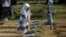 A girl places flowers on the graves of some of the victims who died during the political turmoil of 1998 during a 20th anniversary commemoration at Pondok Ranggon mass grave in Jakarta, Indonesia, May 13, 2018. 