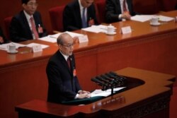FILE - Zhang Jun, then-procurator-general of China's Supreme People's Procuratorate, delivers a report at the Great Hall of the People in Beijing, March 12, 2019.