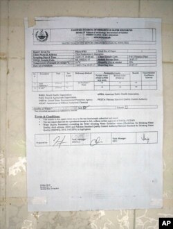A certificate pasted to a wall at a water filtration plant, where the water is provided from a tube well, declares that the water at the site is safe, in Islamabad, Pakistan, Aug. 23, 2017.