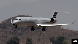 An American Eagle jet is seen through heat ripples as it lands at Sky Harbor International Airport, June 19, 2017, in Phoenix. American Airlines cancelled dozens flights out of Phoenix today due to extreme heat. 