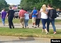 Evacuees walk away from a building following a shooting at the municipal center in Virginia Beach, Va., May 31, 2019, in this still image taken from video.
