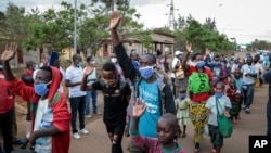 Burundian refugees from Mahama camp in Rwanda wave to gathered media as they arrive back in Gasenyi, Burundi, Aug. 27, 2020.