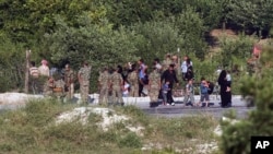 FILE - Newly arrived Syrians enter Turkey as several others wait inside Syria to cross the border near the Turkish village of Guvecci in Hatay province, June 19, 2011. As the border tightened, refugees fortunate enough to reach the frontier started bribing Turkish guards to let them in.