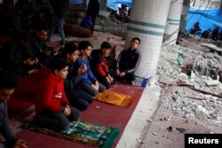 Palestinians perform Friday prayers at the ruins of a mosque destroyed in Israeli strikes in Rafah, southern Gaza Strip, on Feb. 23, 2024.