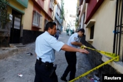 FILE - Police officers secure the scene of an explosion where a suspected suicide bomber targeted a wedding celebration in Gaziantep, Turkey, Aug. 21, 2016.