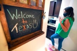 FILE - Megan Carlton with the Refugee Services of Texas walks through a home her organization set up for an Afghani refugee family in Dallas, Aug. 17, 2021.