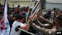 Pengunjuk rasa anti-pemerintah bentrok dengan polisi di luar kantor polisi di Bangkok, 28 Agustus 2020 ketika para pemimpin mahasiswa dipanggil oleh polisi setelah serangkaian demonstrasi pro-demokrasi. (Foto oleh Patipat JANTHONG / THAI NEWS PIX / AFP)