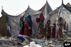 FILE - Watoto wa wakimbizi wa Afghanistan wakicheza nje ya eneo la Afghan Basti nje ya mji wa Lahore Juni 19, 2021 katika maadhimisho ya Siku ya Wakimbizi Duniani.