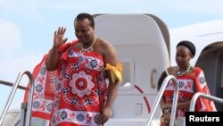 FILE - King of Swaziland Mswati III and one of his 13 wives disembark from a plane after arriving at Katunayake International airport in Colombo, Sri Lanka, August 13, 2012. 