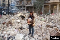 مردی در میان آوارها ایستاده است در حالی که جستجو برای بازماندگان ادامه دارد