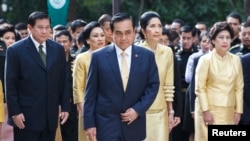 FILE - Thailand's Prime Minister Prayuth Chan-ocha (C), his wife Naraporn Chan-ocha (2nd R) and his cabinet pray for the health of Thailand's revered King Bhumibol Adulyadej, at the Siriraj hospital in Bangkok.