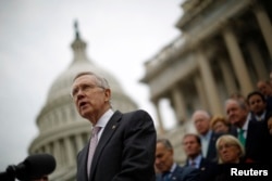 FILE - U.S. Senate Majority Leader Harry Reid, with other Democratic Party Senate members in the background, is seen on the steps of the U.S. Capitol in Washington, D.C.