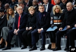 FILE - U.S President Donald Trump, second left, and first lady Melania Trump, left, German Chancellor Angela Merkel, third left, French President Emmanuel Macron and his wife Brigitte, and Russian President Vladimir Putin, right, attend ceremonies at the Arc de Triomphe in Paris, Nov. 11, 2018.