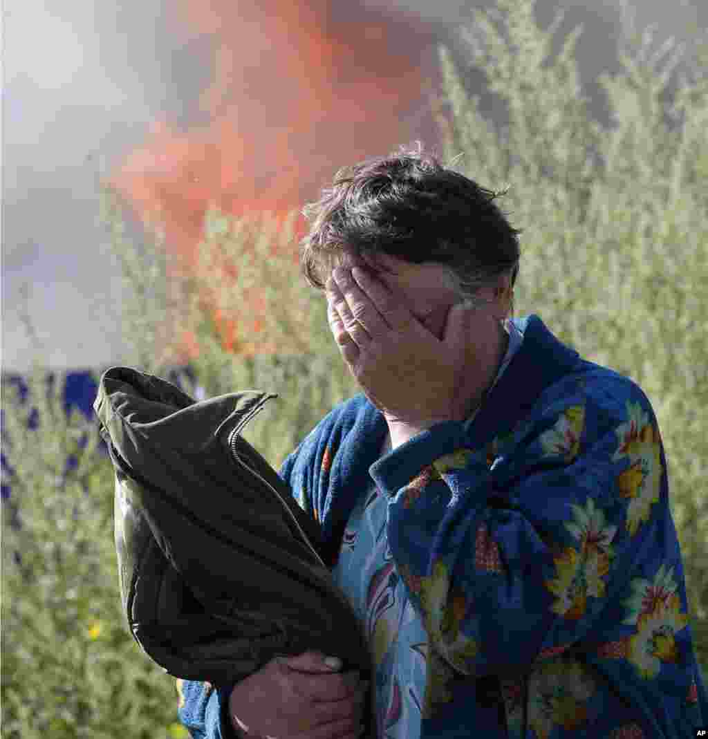 A woman cries near her burning house after shelling by government forces in the city of Slovyansk, Donetsk Region, eastern Ukraine.