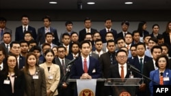 (ซ้ายไปขวา บนโพเดียม) พิธา ลิ้มเจริญรัตน์ และชัยธวัช ตุลาธน อดีตหัวหน้า และหัวหน้าพรรคก้าวไกลคนปัจจุบัน แถลงข่าวร่วมกันหลังคำสั่งศาลรัฐธรรมนูญเมื่อ 31 มกราคม 2024 (ที่มา: AFP)