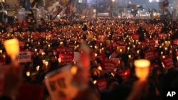 지난 19일 서울에서 열린 박근혜 한국 대통령 하야 촉구 시위에서 참석자들이 촛불을 들고 있다.