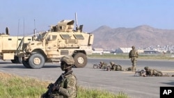US soldiers stand guard along a perimeter at the international airport in Kabul, Afghanistan, Aug. 16, 2021.