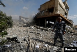 A Syrian firefighter is seen inside the destroyed Scientific Research Centre in Damascus, Syria April 14, 2018.