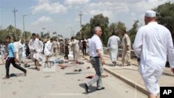 Warga berkumpul di lokasi serangan bom di Baqouba, timur laut Baghdad, Irak, Jumat (17/5).