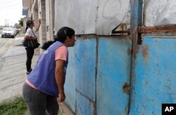 In this March 3, 2018 photo, public health workers go door-to-door in a neighborhood on the outskirts of Sao Paulo, Brazil, as part of a massive campaign to vaccinate people against yellow fever.