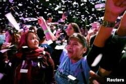 Adrian Avella and Mazeda Uddin react during the midterm election night party of Democratic congressional candidate Alexandria Ocasio-Cortez in New York City, Nov. 6, 2018.