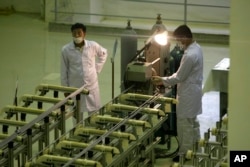FILE - Iranian technicians work at a facility producing uranium fuel outside of Isfahan, 410 kilometers south of the capital, Tehran.