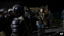 Police block the road toward Kyrgyzstan's ex-president Almazbek Atambayev's residence in the village of Koi-Tash, about 20 kilometers (12 miles) south of the capital, Bishkek, Kyrgyzstan, Aug. 7, 2019.