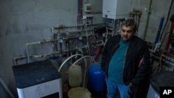 Andriy Gorghinskyyb 49, stoji u svojoj kući sa autonomnim grijanjem, u selu Maljutjanka blizu Kijeva, Ukrajina, utorak, 10. oktobar 2023.