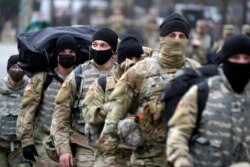 Garda Nasional berjalan di dekat Gedung Capitol di Washington D.C., saat keamanan di sekitar kawasan tersebut ditingkatkan menjelang pelantikan Presiden terpilih Joe Biden dan Wakil Presiden terpilih Kamala Harris, Minggu, 17 Januari 2021. (Foto AP / Julio Cortez)